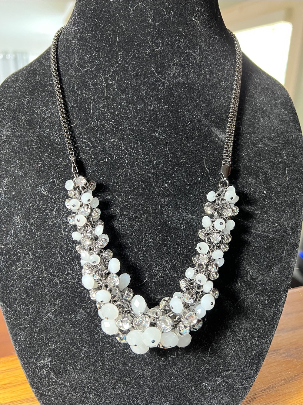 Pale blue to white milky beads, clear rhinestones on a gun mental rope chain.